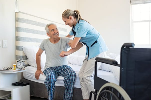 Staff assisting a resident in a bedroom