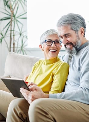Two seniors enjoying time together with a tablet