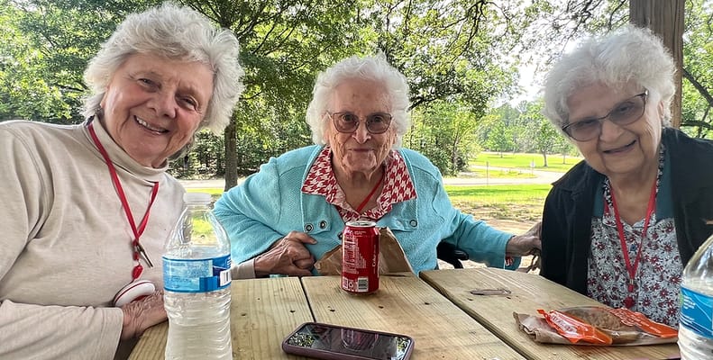 Three residents enjoying time outdoors in a garden