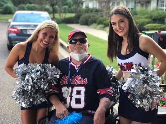 Senior resident with cheerleaders at an outdoor event