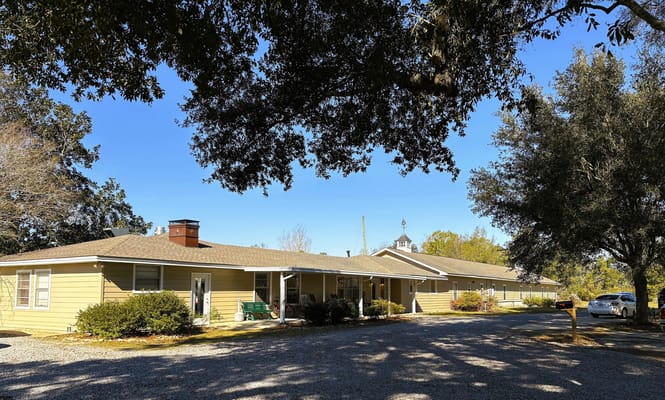 Exterior view of St. Oaks Care Center under a blue sky