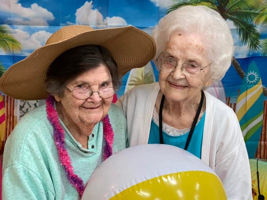 Two residents enjoying a beach-themed event with a beach ball