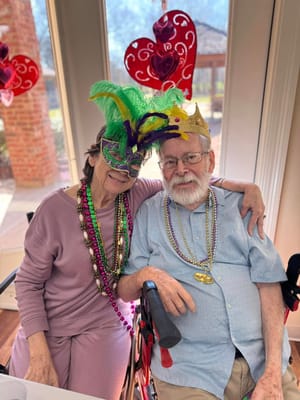 Residents celebrating with masks and beads at a festive event