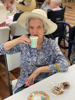 Resident enjoying tea and snacks at a social gathering