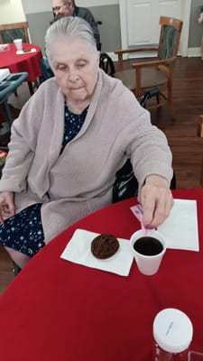 Resident enjoying coffee and a cookie at a table