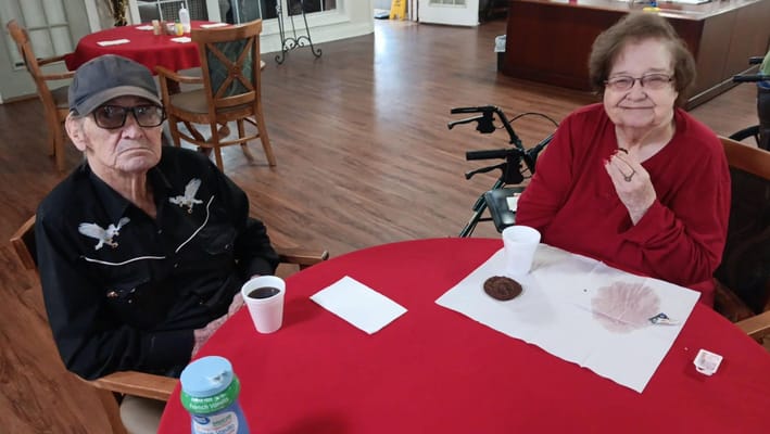 Two residents enjoying snacks at a table