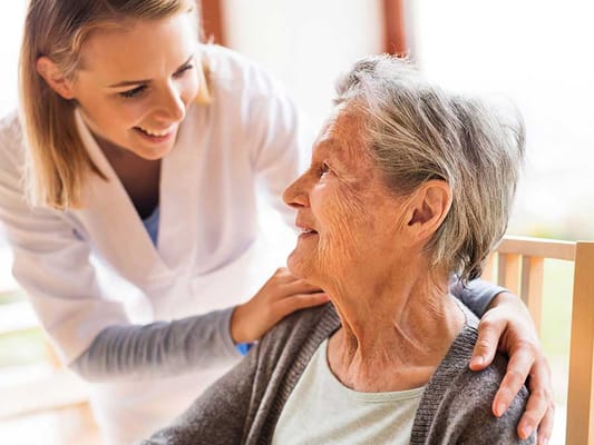 Staff member engaging with a resident in a warm setting