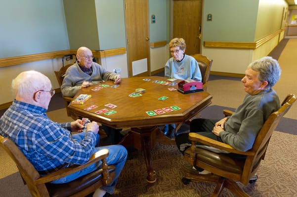 Residents playing a card game in the activity room