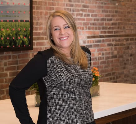 Staff member smiling in a welcoming interior space