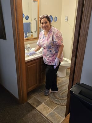 Staff member cleaning a bathroom in a private room