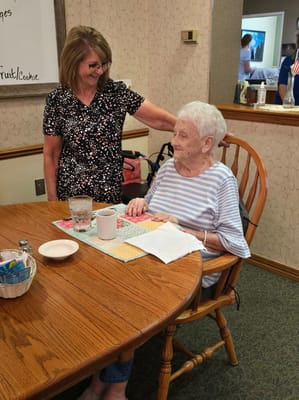 Staff assisting a resident at a dining table