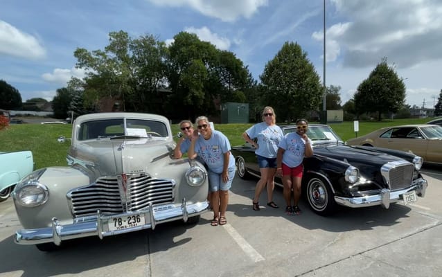 Residents enjoying classic cars display in an outdoor space
