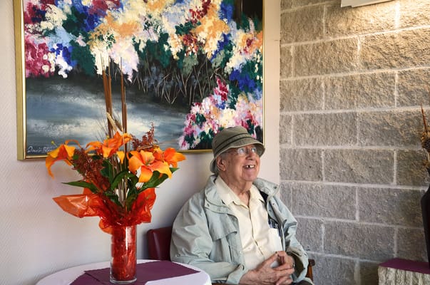 Senior man sitting in a brightly decorated common area