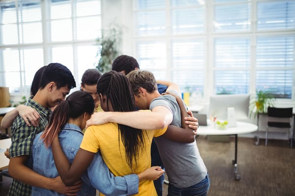 Residents and staff in a group huddle during an activity
