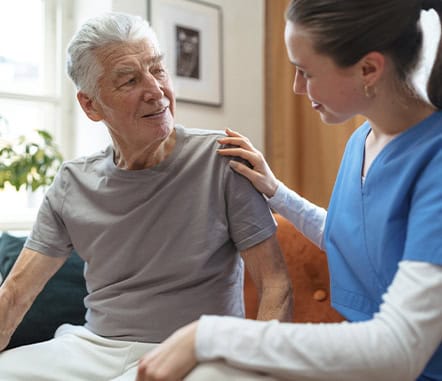 A senior man interacting with a caregiver in a cozy room
