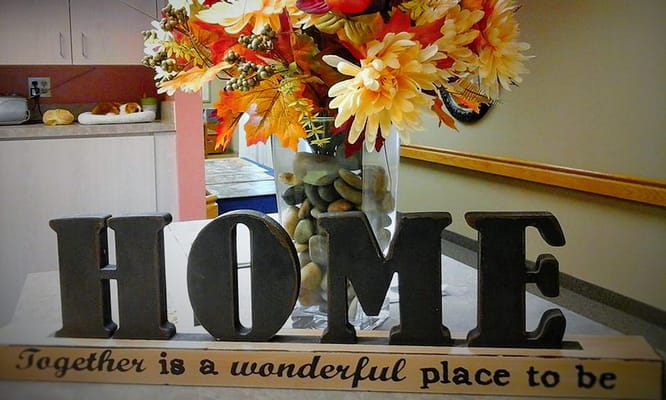 Decorative 'HOME' sign in a cozy facility interior