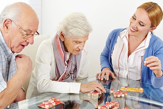 Residents and staff enjoying a game in a bright room