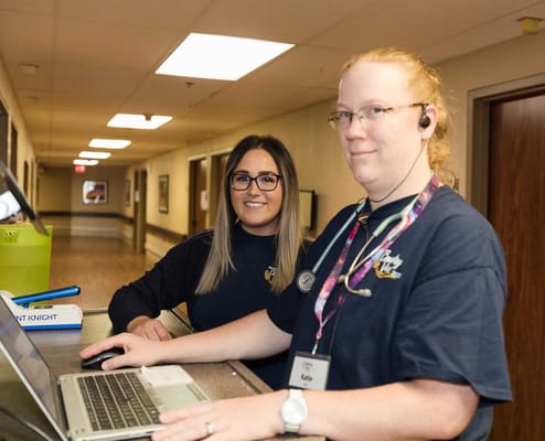 Staff assisting at a reception desk in a facility hallway