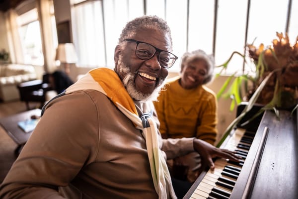 Two residents enjoying music at a piano