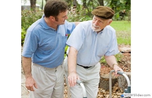 A caregiver assisting a senior man outdoors