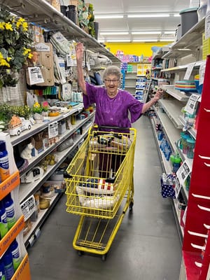 Senior woman shopping with a yellow cart in aisle