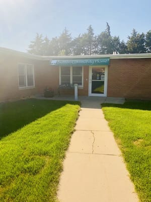 Front entrance of Sutton Community Home with green sign