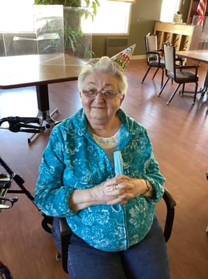 Resident celebrating with a birthday hat in a common area