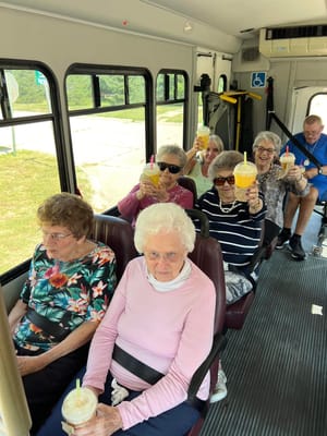 Residents enjoying drinks on a facility shuttle bus