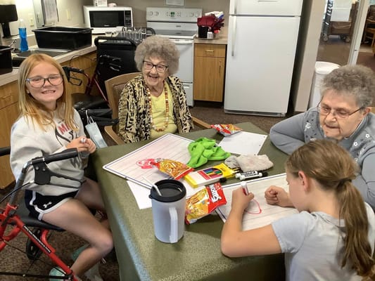 Residents and a child engaging in an arts and crafts activity