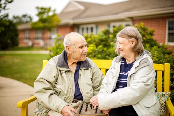 Elderly couple playing chess in an outdoor setting