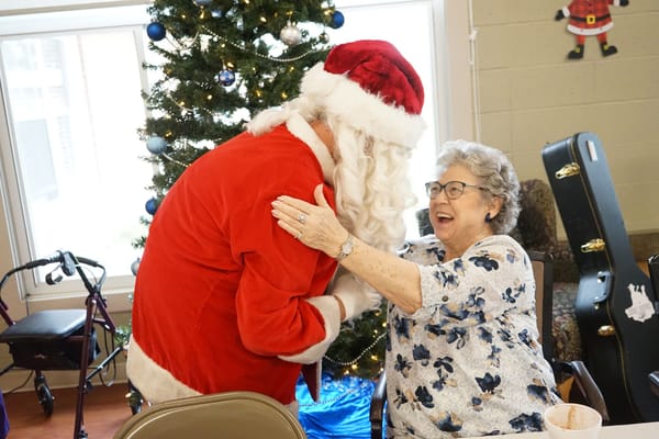 Resident joyfully interacting with Santa Claus