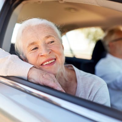Senior woman enjoying the view from a car window
