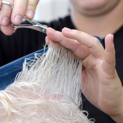 Stylist cutting hair for a resident in a salon