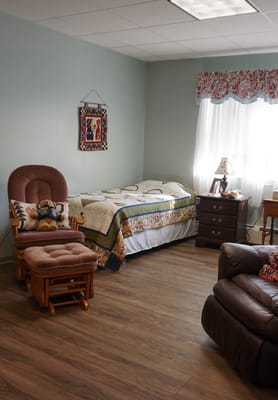 A cozy resident room with a bed and seating area