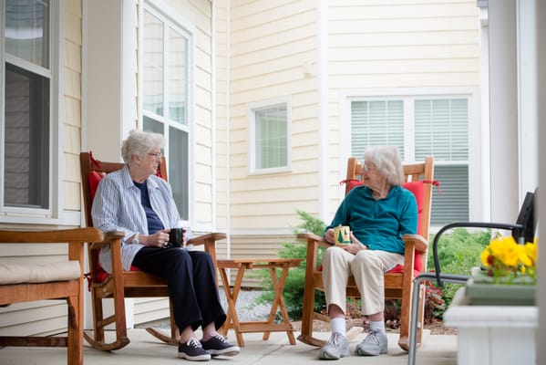 Two residents enjoying conversation on the porch