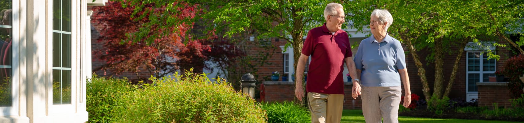 Two residents walking in a garden area