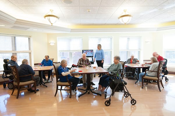 Residents engaging in an activity in a bright activity room