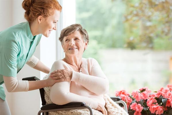 A caregiver smiling with a resident in a well-lit room