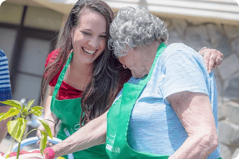 A staff member and resident enjoying gardening together