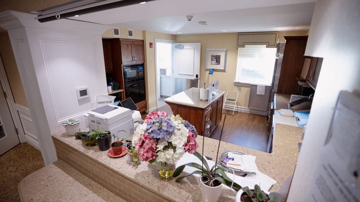 Inside view of a dining area with flowers and kitchen equipment