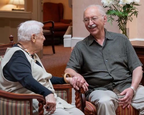 Two residents chatting in a cozy common area