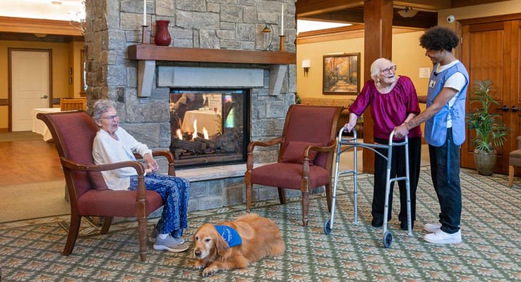 Residents interacting in a cozy common area by the fireplace