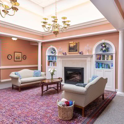 Warm and inviting interior common area with seating and bookshelves