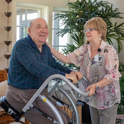 A staff member assisting a resident with a physical activity