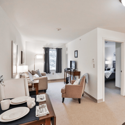 A cozy resident room with a seating area and TV