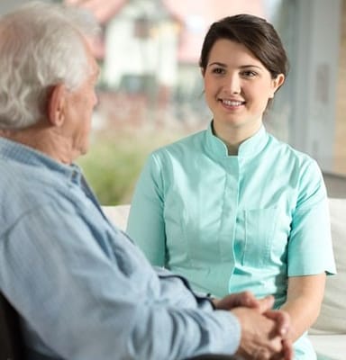 A caregiver smiling while talking with a resident