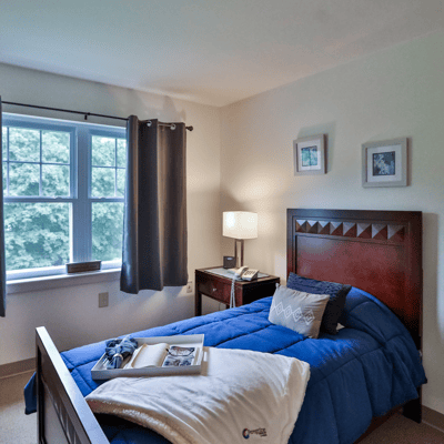 Cozy private room with bed and bedside lamp