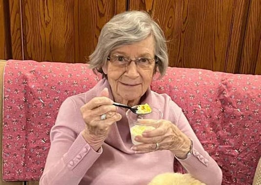 Senior woman enjoying dessert in a cozy living space