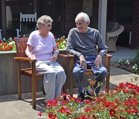Two residents enjoying conversation in a garden area