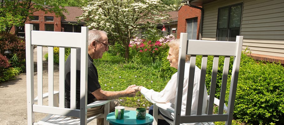 Two residents sitting together in a garden area
